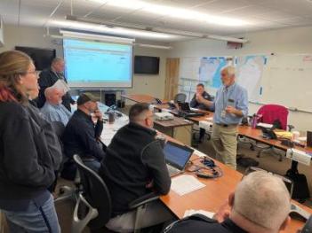 Group of people in a room with a projector.